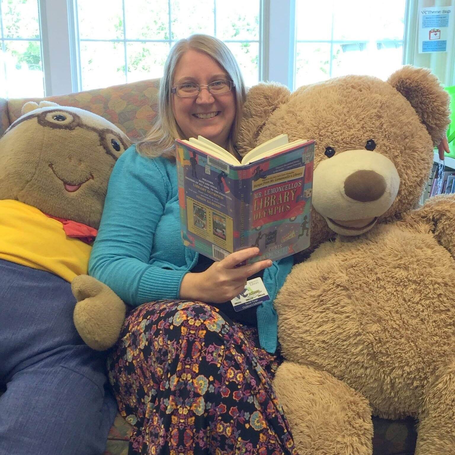 photo of Vargo reading book between two stuffed animals